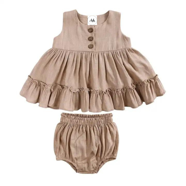 Linen Ruffle Dress Set - Beautiful Beige Our adorable baby linen ruffle dress ser, the perfect addition to your little one's wardrobe! Made from high-quality linen, cotton materials, this dress set is both soft and comfortable for your baby's delicate skin, while also being breathable enough for everyday wear. Featuring a charming ruffle design, this romper is both stylish and cute, making it perfect for any occasion. Whether it's a family gathering or a day out with friends, your little one will look absolutely adorable in this set. This set features gorgeous wood buttons and matching bloomers for under the ruffle dress, making nappy changes easy. It can easily be layered with long sleeves and tights for cooler temperatures. Available in a variety of colors and sizes at Ash. The Label, our baby linen ruffle dress set is the perfect choice for parents who want to dress their little one in style and comfort. So why wait? Order yours today and give your baby the gift of style and comfort! Care 70% Cotton 30% Linen Gentle Machine wash in garment bag Warm Iron Warm tumble try